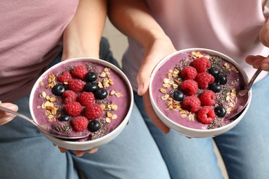 Photo of Women with tasty natural acai smoothie, closeup