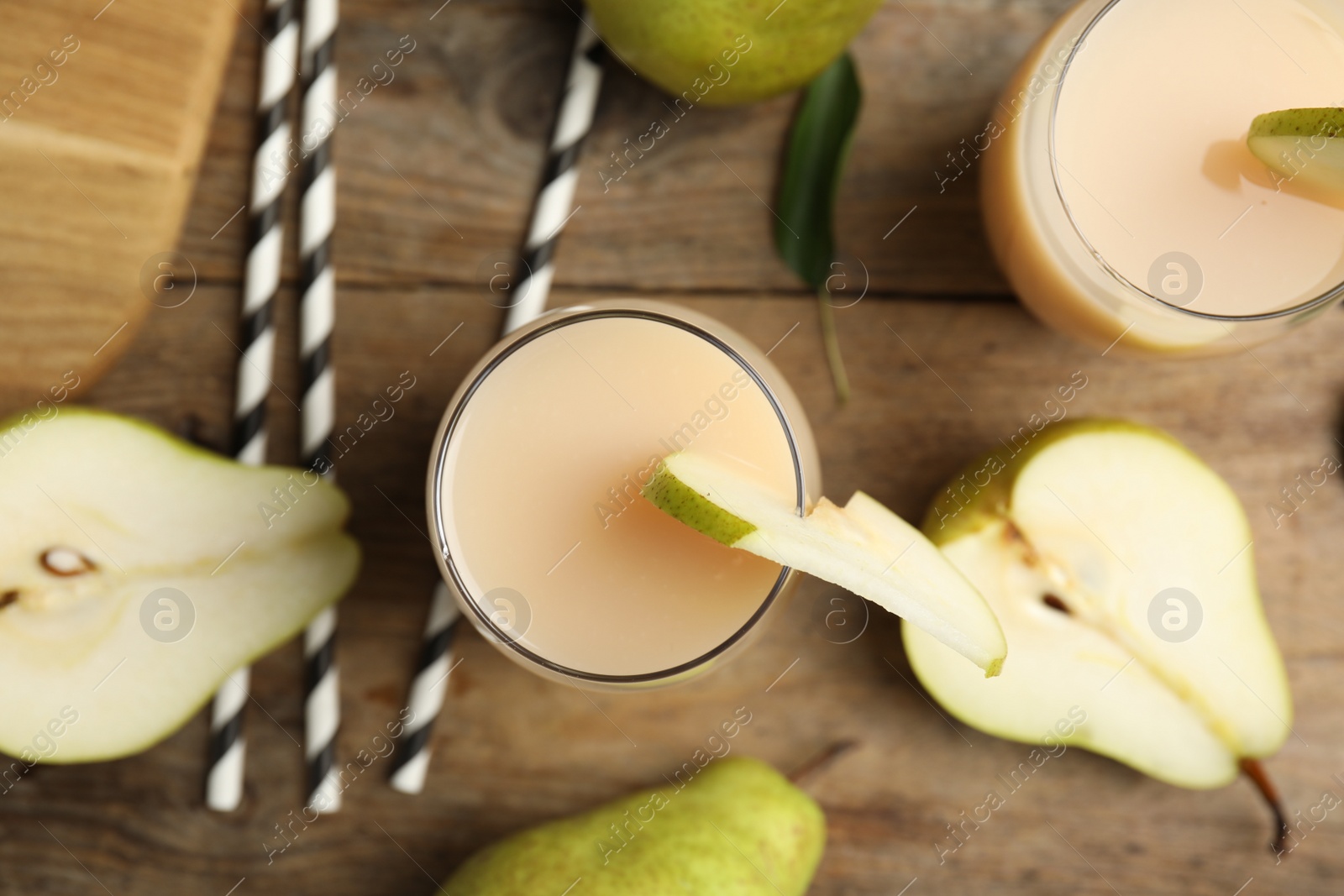 Photo of Tasty pear juice, fruits and straws on wooden table, flat lay