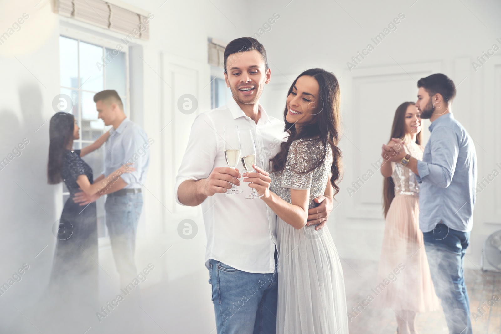 Photo of Lovely young couple with glasses of champagne at dancing party