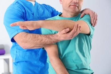 Photo of Doctor working with patient in hospital, closeup. Rehabilitation physiotherapy