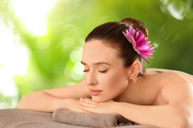 Image of Beautiful young woman relaxing on soft towel. Spa treatment