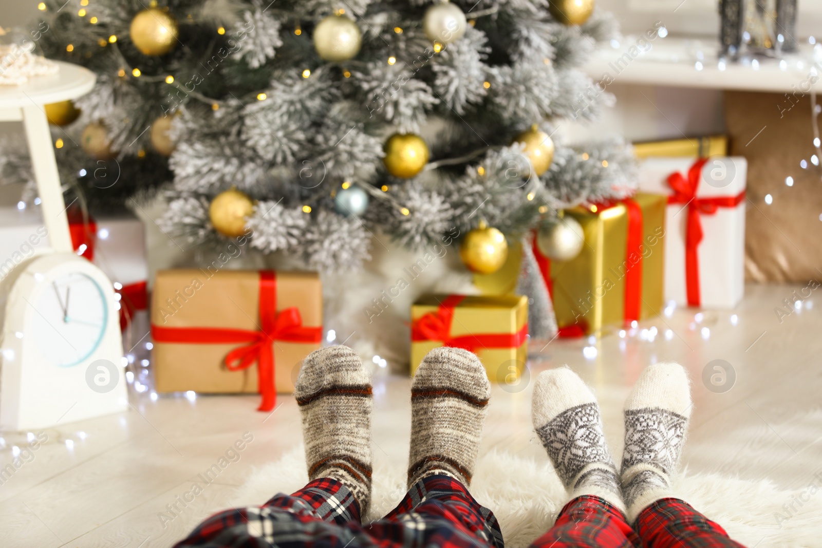 Photo of Young couple near Christmas tree at home, closeup