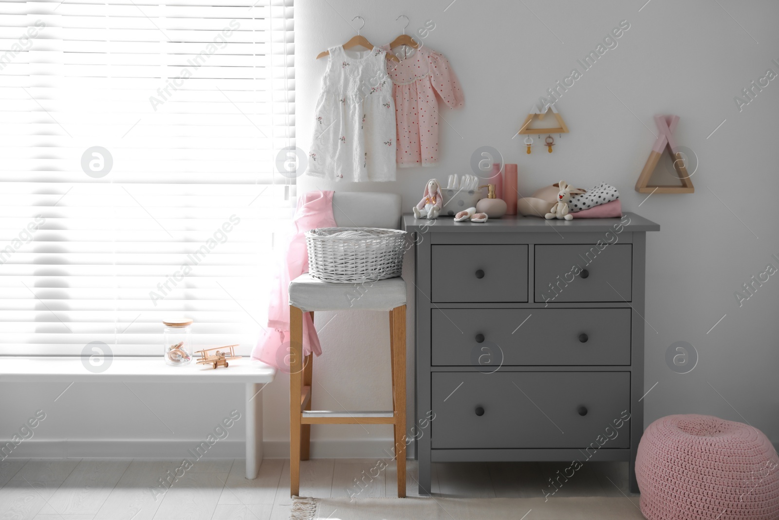 Photo of Stylish chest of drawers and accessories in child room