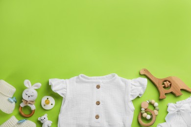 Photo of Flat lay composition with baby clothes and accessories on green background, space for text