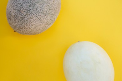 Photo of Different tasty ripe melons on yellow background, flat lay