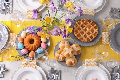 Photo of Festive Easter table setting with traditional meal, top view