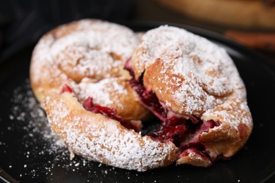 Photo of Delicious buns with berries and sugar powder on plate, closeup