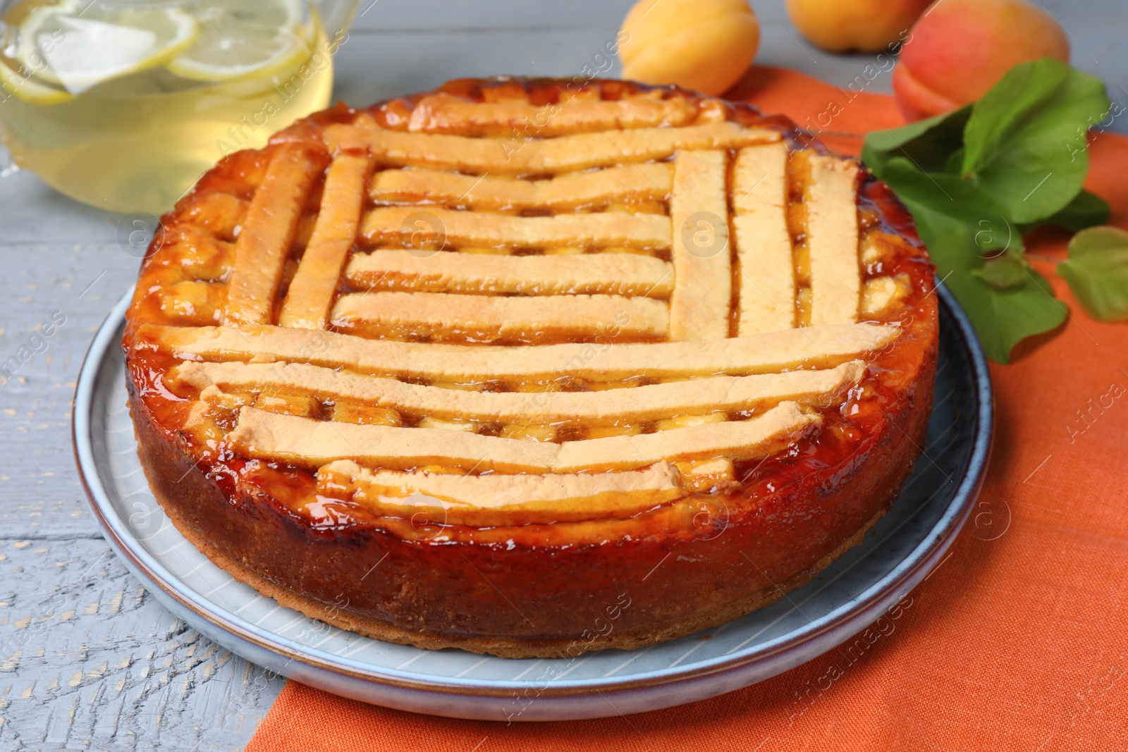 Photo of Tasty apricot pie on grey wooden table, closeup
