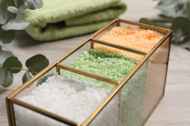 Different types of sea salt on wooden table, closeup