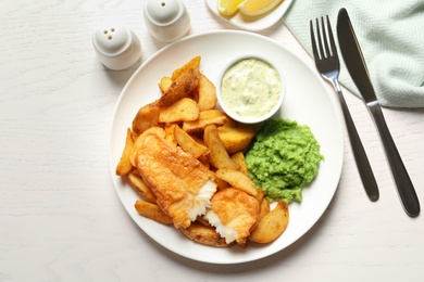 Photo of British Traditional Fish and potato chips on wooden background, flat lay