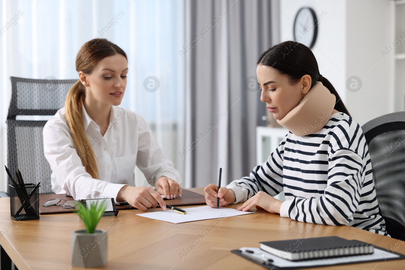 Photo of Injured woman signing document in lawyer's office