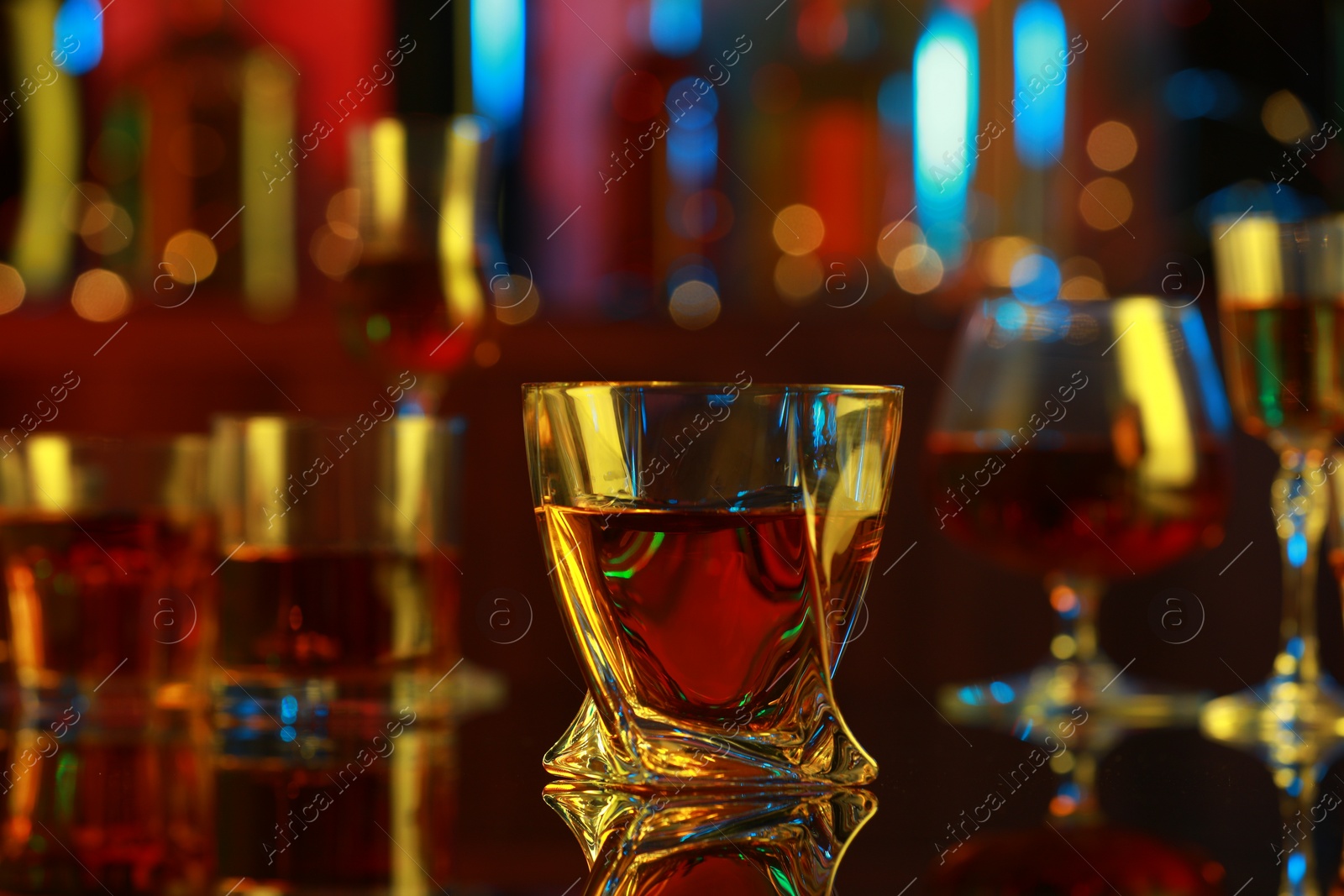 Photo of One liqueur in glass on mirror table in bar