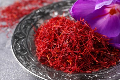 Dried saffron and crocus flower on grey table, closeup