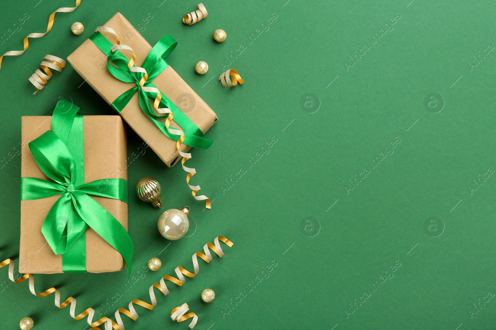 Photo of Flat lay composition with serpentine streamers and Christmas decor on green background. Space for text