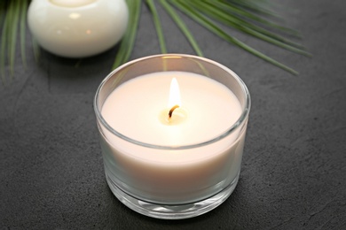 Photo of Aroma candle on grey background, closeup. Spa setting