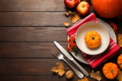 Photo of Flat lay composition with tableware, autumn fruits and vegetables on wooden background, space for text. Thanksgiving Day