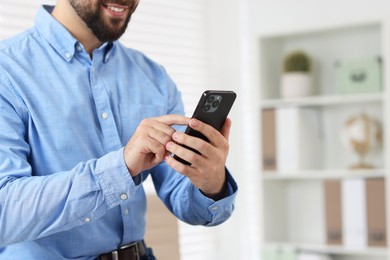 Photo of Man using smartphone in office, closeup. Space for text