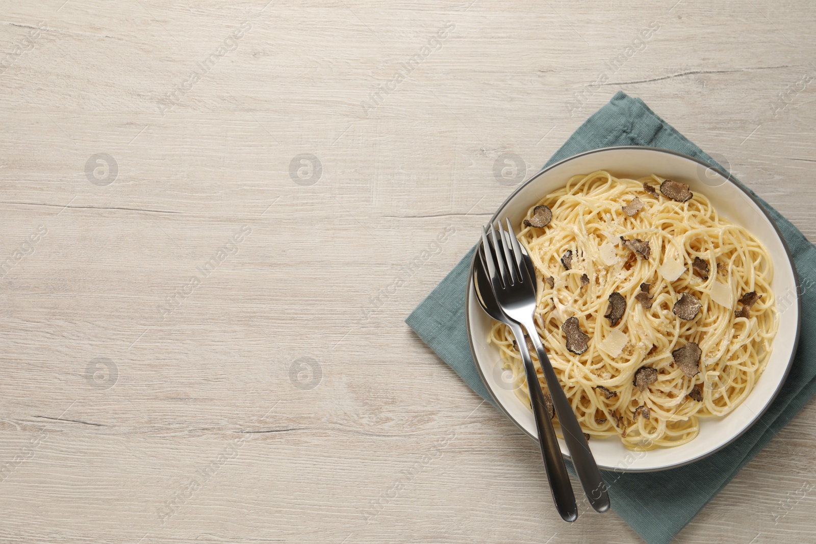 Photo of Tasty spaghetti with truffle on wooden table, top view. Space for text