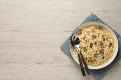 Tasty spaghetti with truffle on wooden table, top view. Space for text