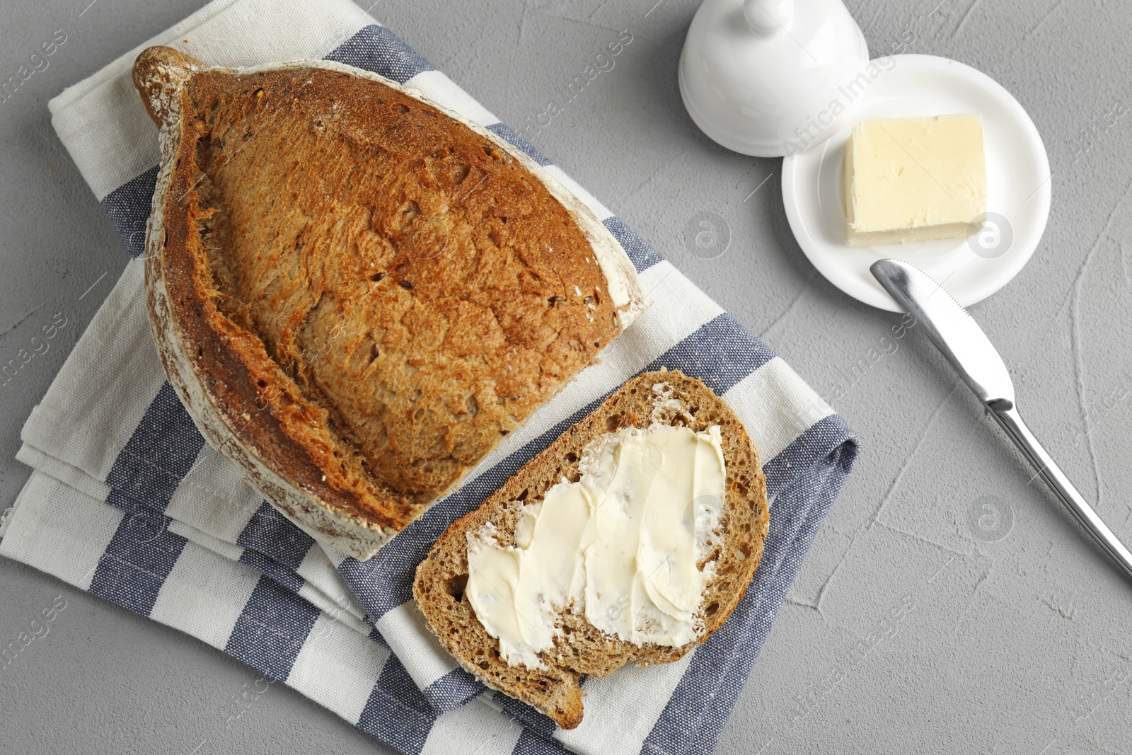 Photo of Flat lay composition with bread and butter on grey table