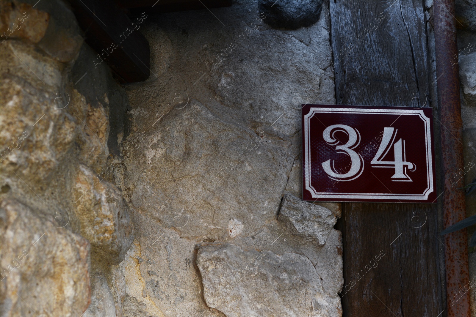 Photo of Plate with house number thirty four on stone wall outdoors