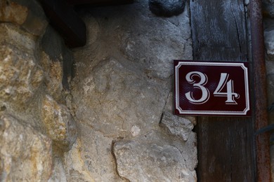 Photo of Plate with house number thirty four on stone wall outdoors