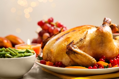 Traditional Thanksgiving day feast with delicious cooked turkey and other seasonal dishes served on light table, closeup