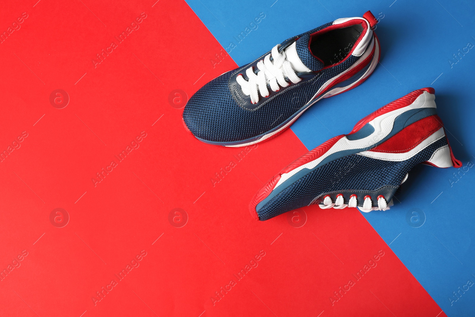 Photo of Flat lay composition of stylish training shoes on color background, space for text