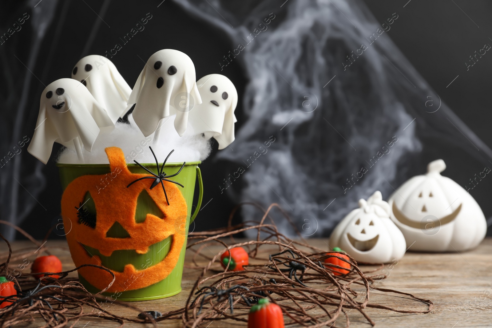 Photo of Ghost shaped cake pops on wooden table, space for text. Halloween treat