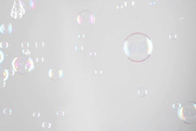 Beautiful transparent soap bubbles on grey background