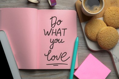 Photo of Open notebook with motivational phrase Do What You Love, cookies and coffee on wooden table, flat lay