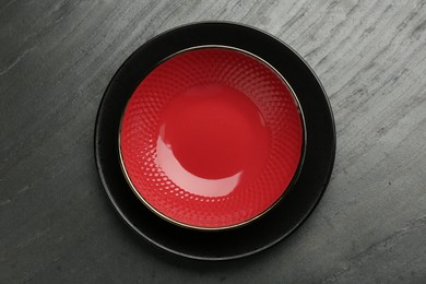 Photo of Beautiful ceramic plate and bowl on black table, top view