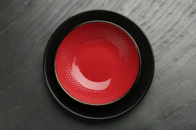 Beautiful ceramic plate and bowl on black table, top view