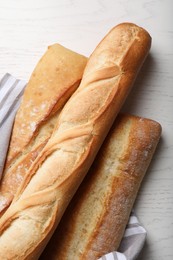 Photo of Different tasty baguettes on white wooden table, flat lay