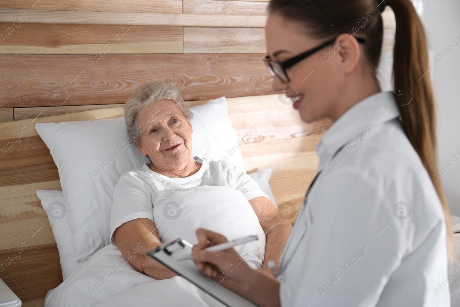 Photo of Doctor examining senior patient in modern hospital