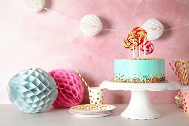 Photo of Stand with fresh delicious cake and birthday decorations on table. Space for text