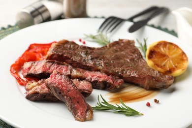 Photo of Delicious grilled beef steak with spices on plate, closeup