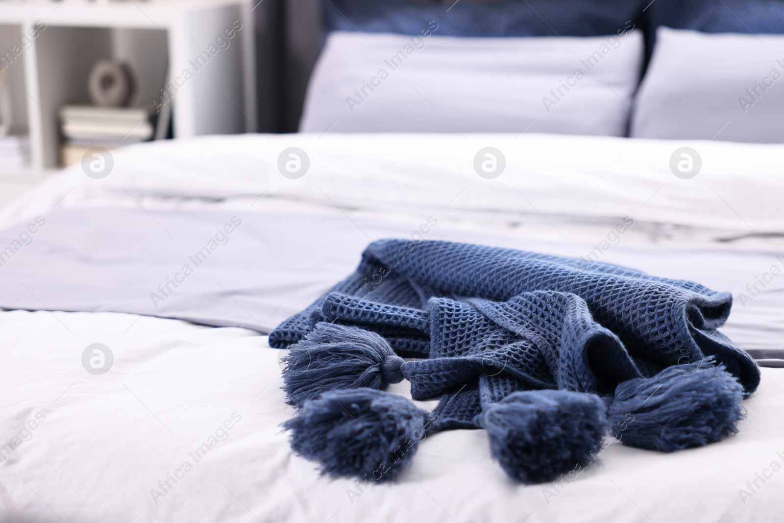 Photo of Soft blue plaid on bed in room, closeup