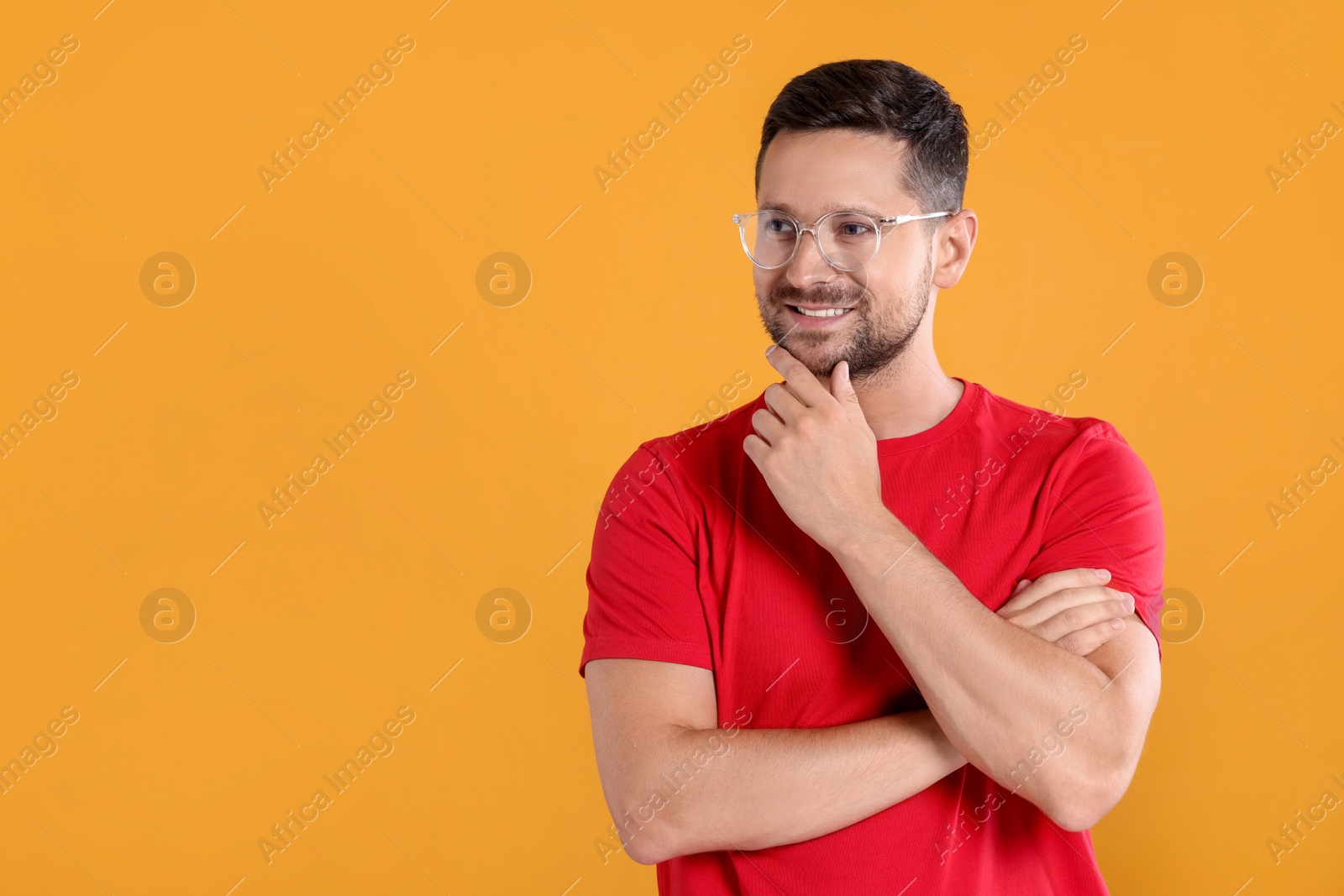 Photo of Portrait of happy man in stylish glasses on yellow background. Space for text