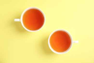 Photo of Cups of delicious tea on color background, top view