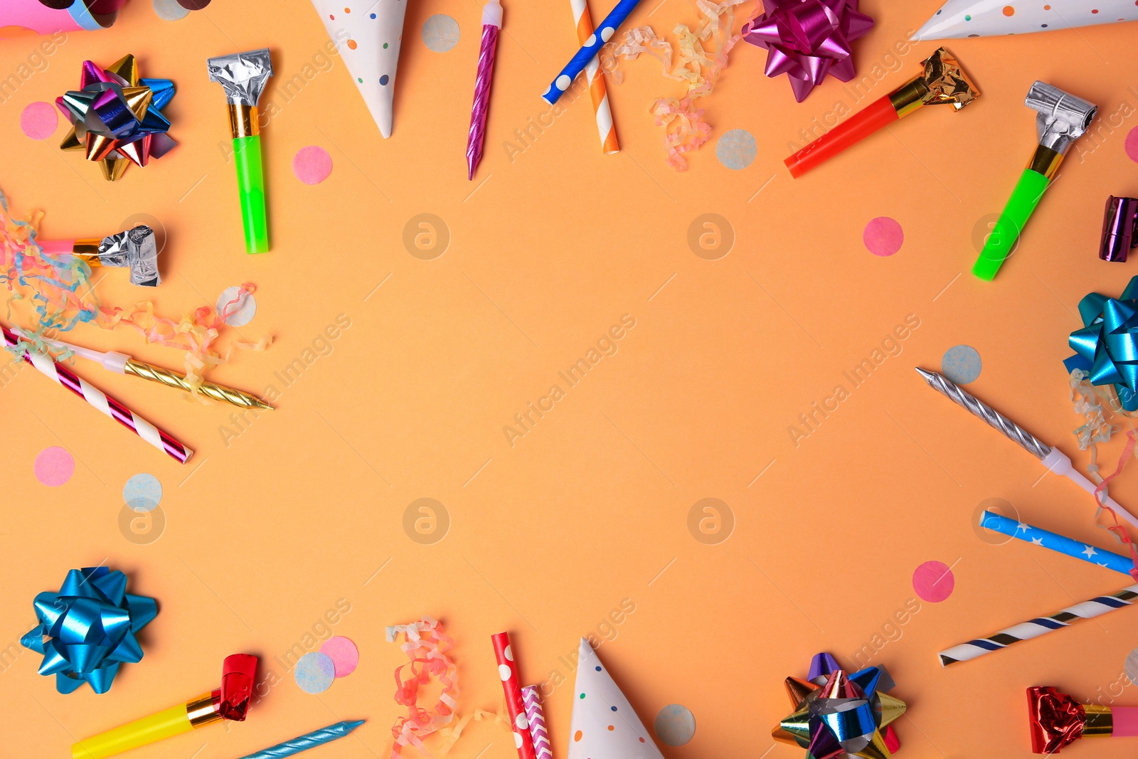 Photo of Frame of party blowers, streamers and other festive decor on coral background, flat lay. Space for text