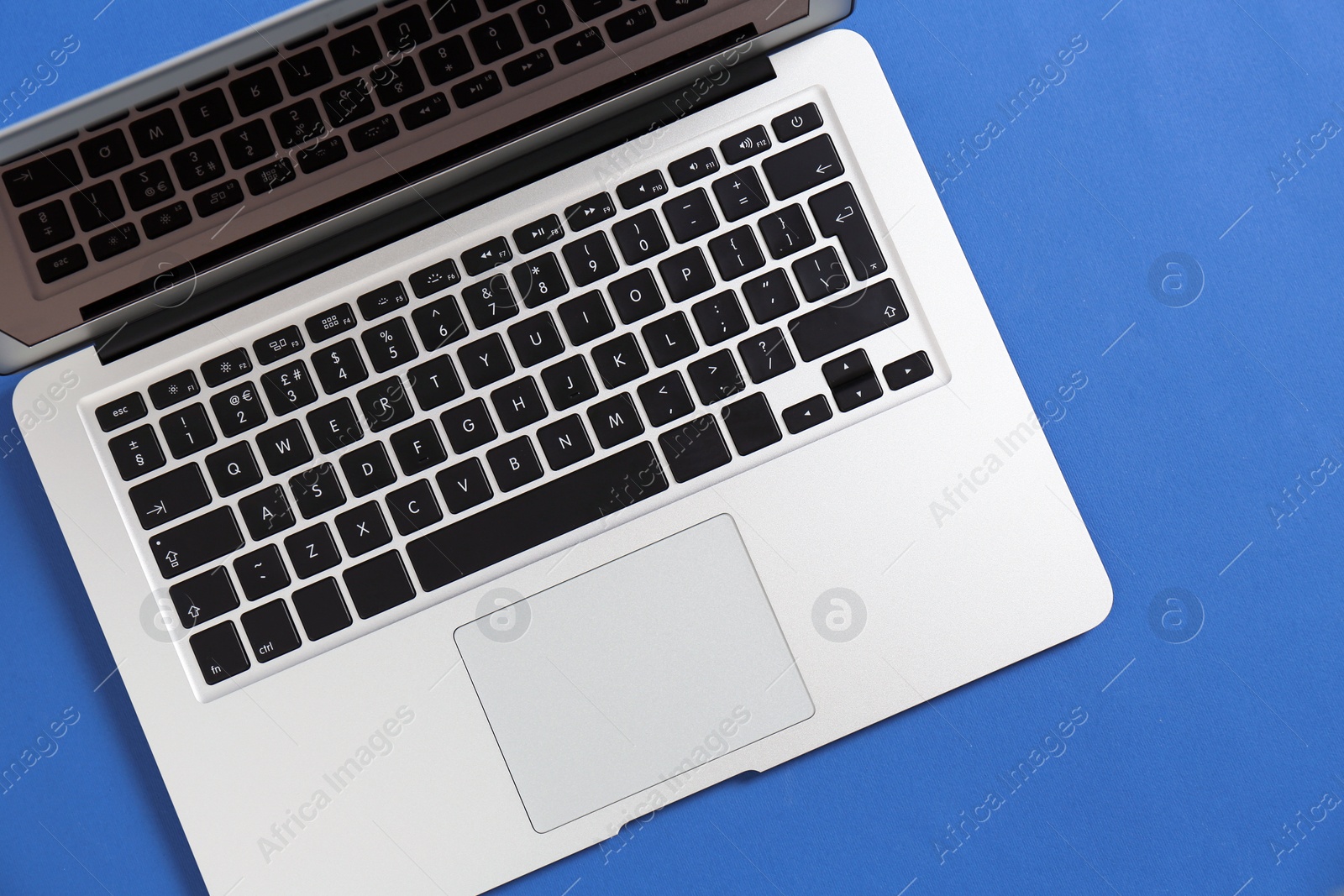 Photo of Modern laptop on color background, top view