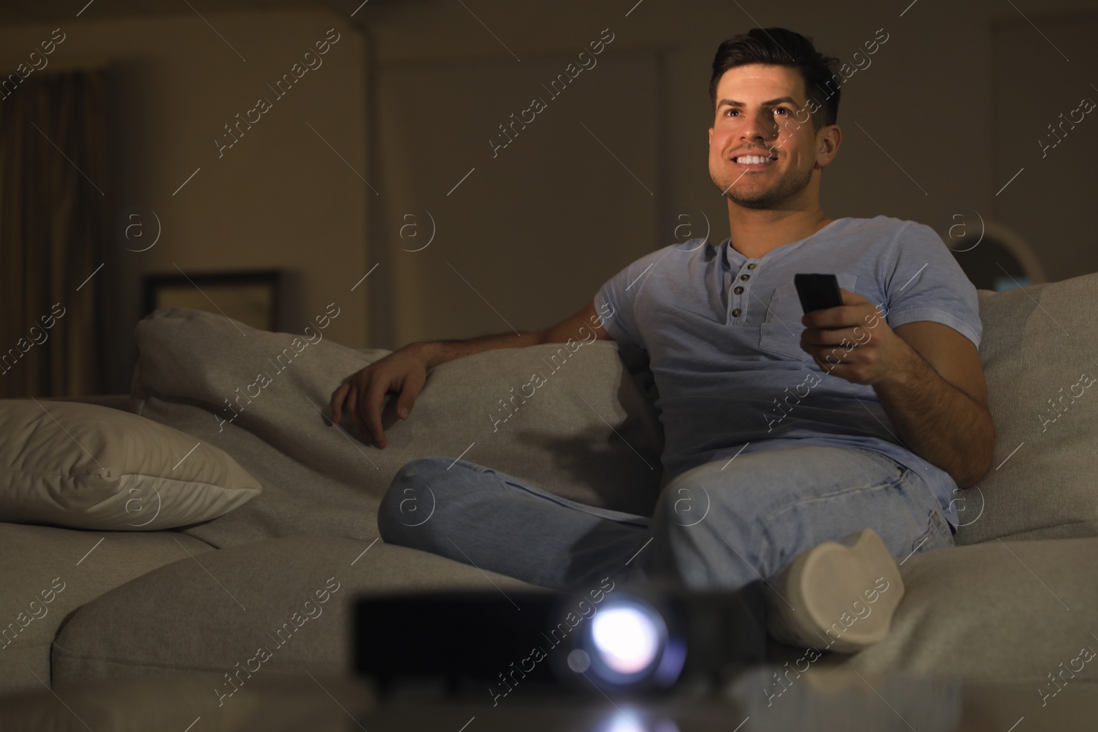 Photo of Man watching movie on sofa at night, space for text