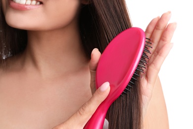 Photo of Woman with hair brush on white background, closeup