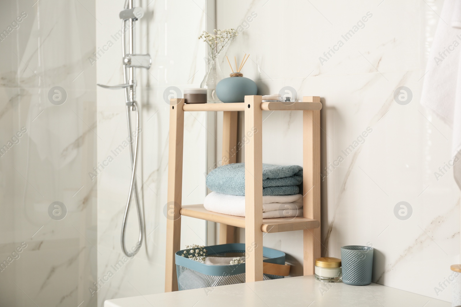 Photo of Shelving unit with clean towels in bathroom interior