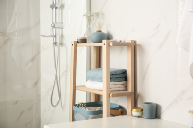 Shelving unit with clean towels in bathroom interior