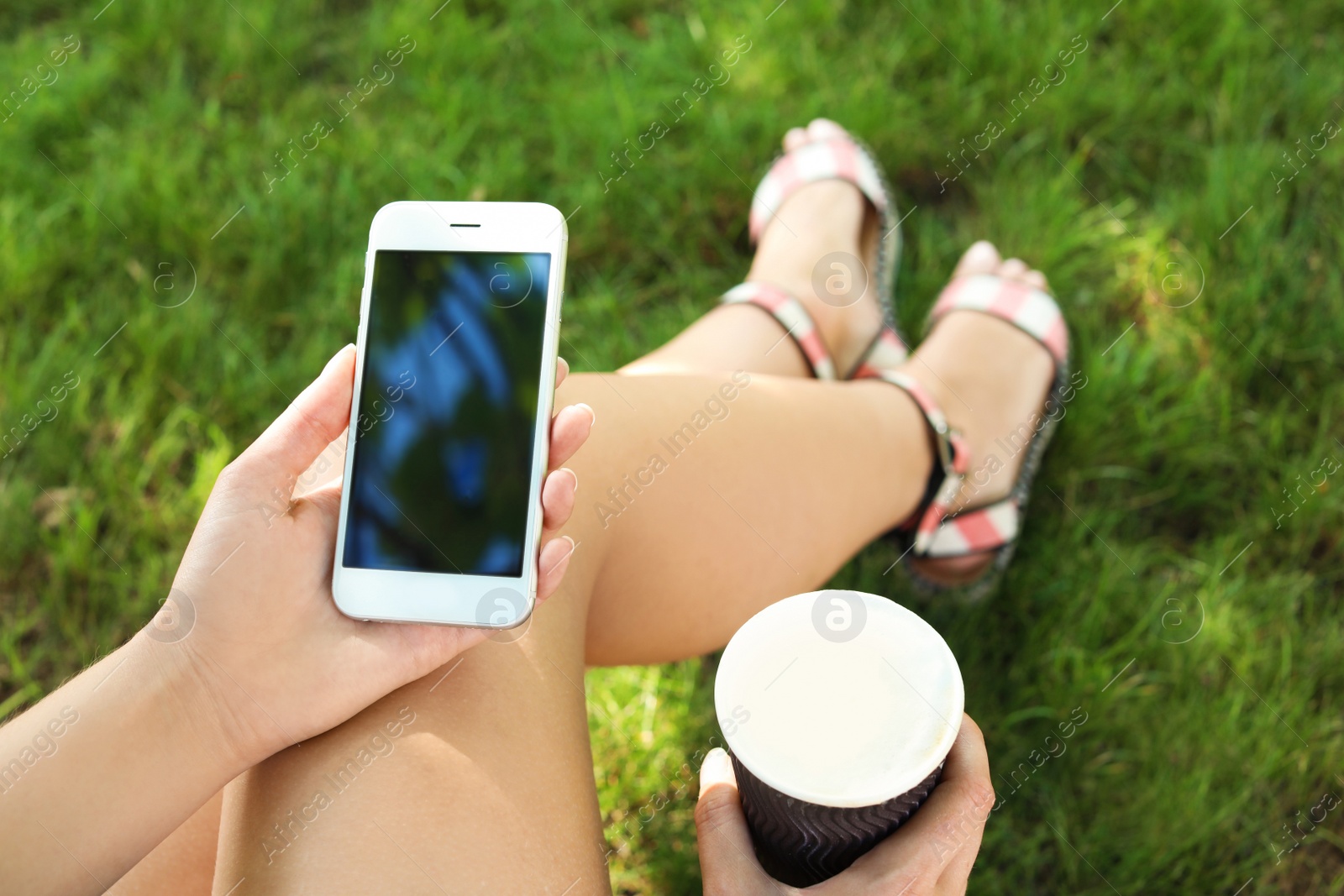 Photo of Woman using smartphone with blank screen outdoors, closeup. Mock up for design