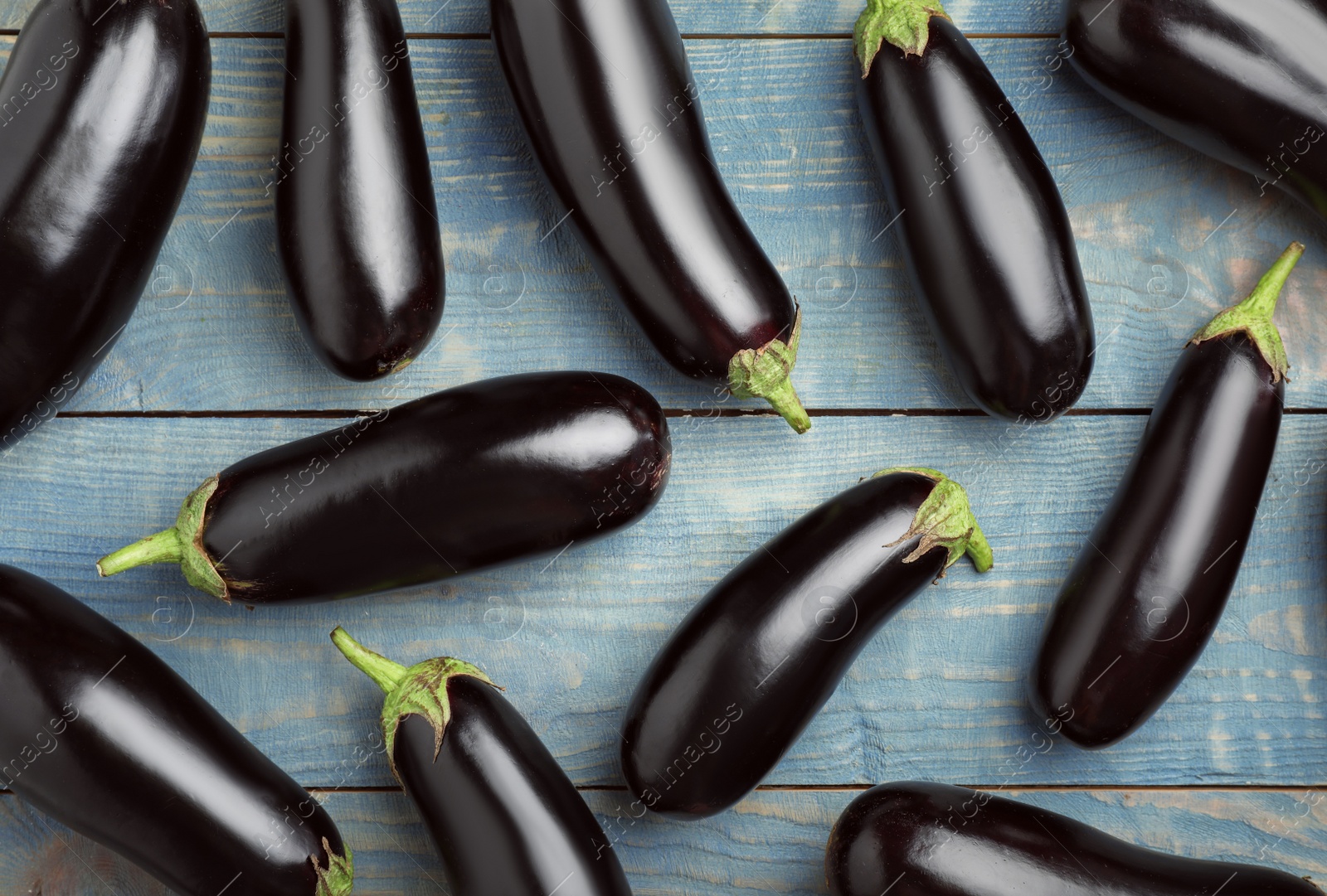 Photo of Raw ripe eggplants on wooden background, top view