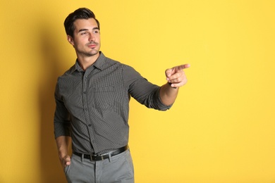 Photo of Young male teacher on yellow background. Space for text