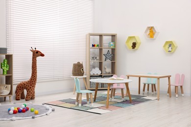 Photo of Stylish kindergarten interior with toys and modern furniture